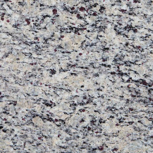 Close-up of granite countertop with white, gray, and dark red flecks.