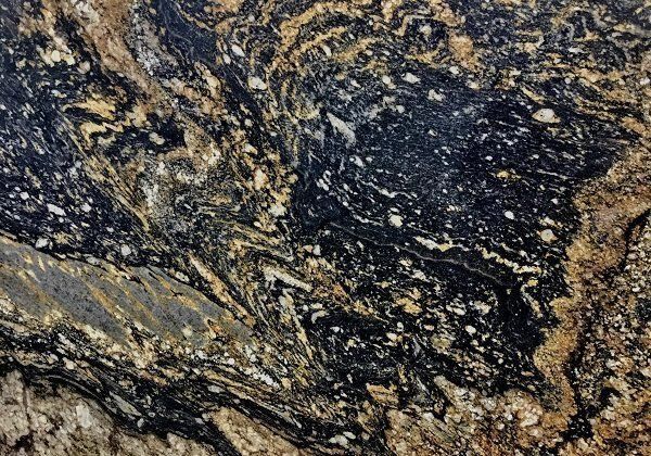 Close-up of a granite slab, swirled black, tan, and gold patterns.