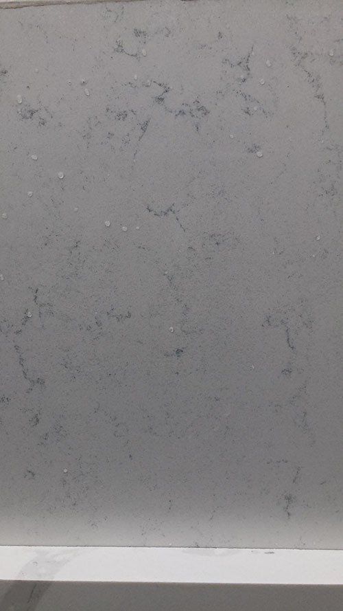 Gray quartz countertop with subtle veining and flecks.