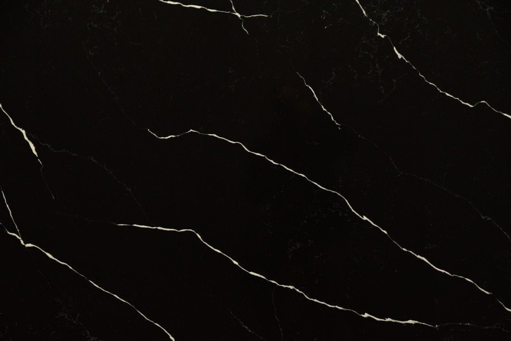 Black surface with white, vein-like streaks.