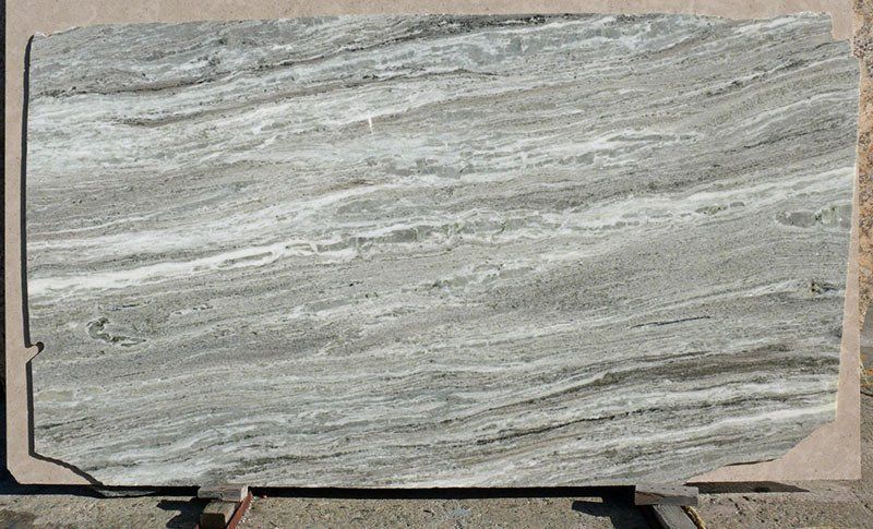 A large slab of gray and white marble with flowing, horizontal patterns.