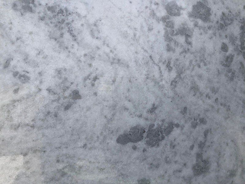 Gray and white marble countertop with mottled patterns.