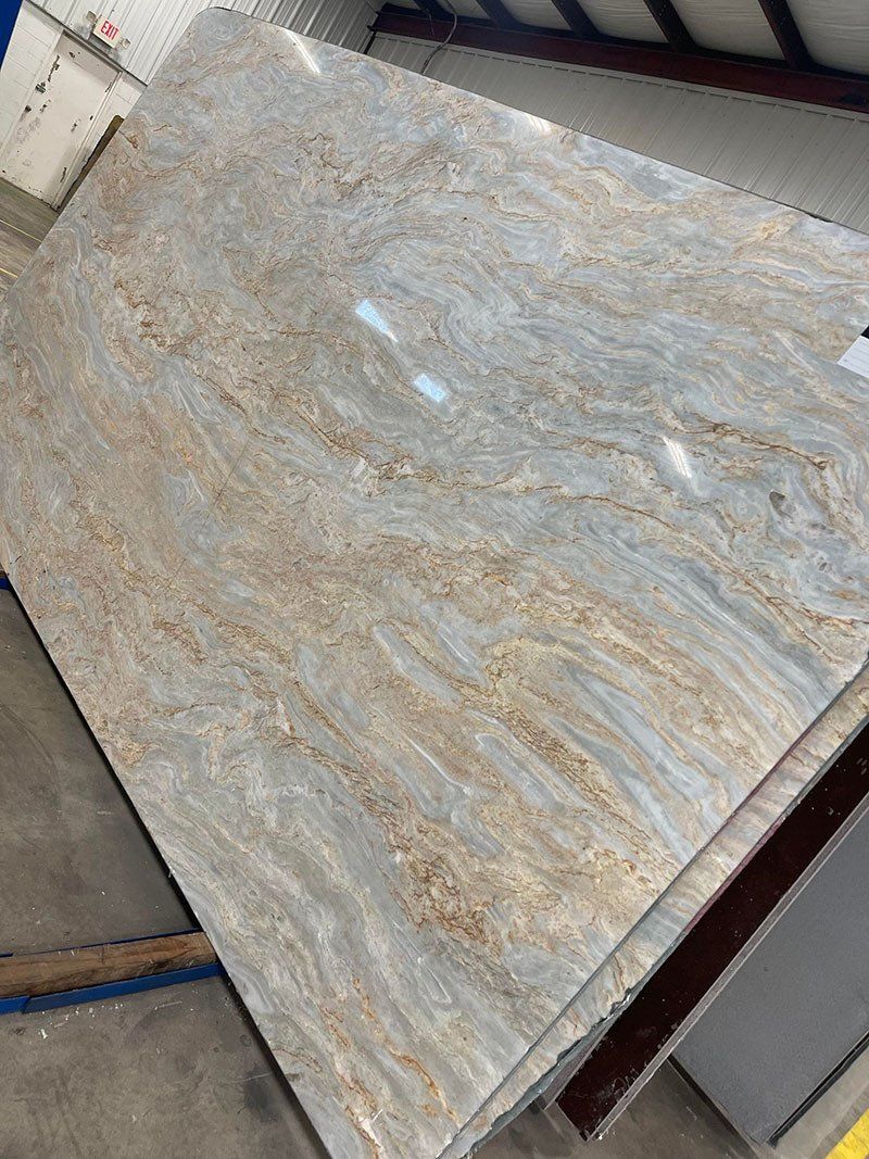 Large, light-colored stone slab with swirling beige and blue-grey patterns.