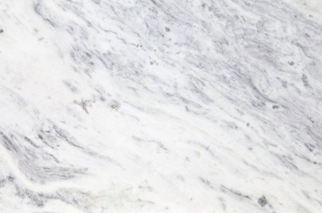 White marble surface with gray veining and subtle speckles.