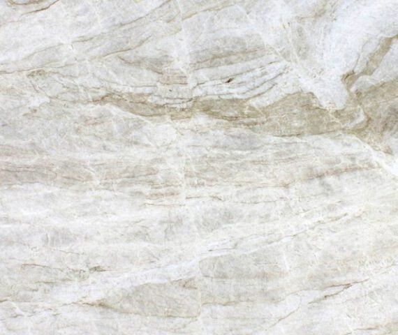 Light-colored stone surface with swirling patterns and streaks of tan and white.