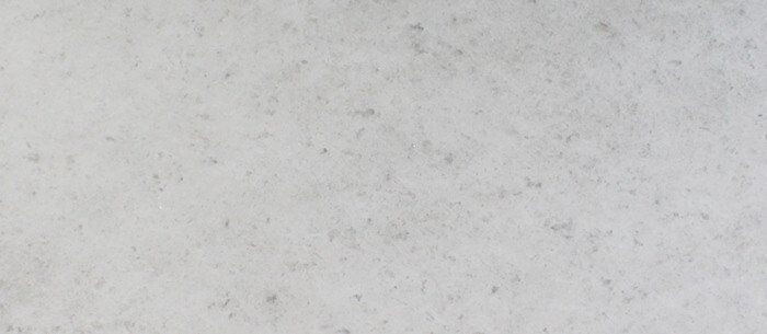 A light gray surface with subtle dark gray flecks.