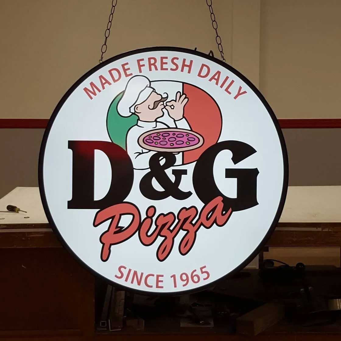 Round D&G Pizza sign. Chef with pizza on Italian flag, text 
