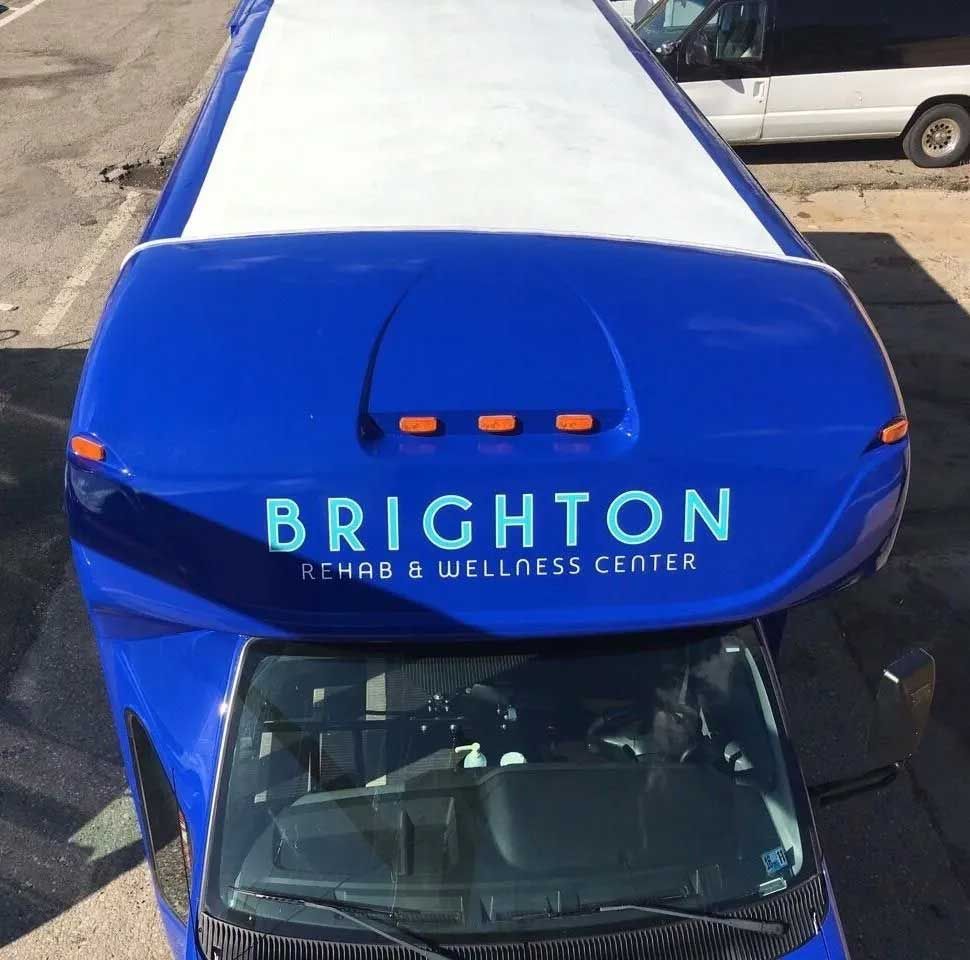 Blue Brighton Rehab & Wellness Center van, aerial view. White roof, logo on front.