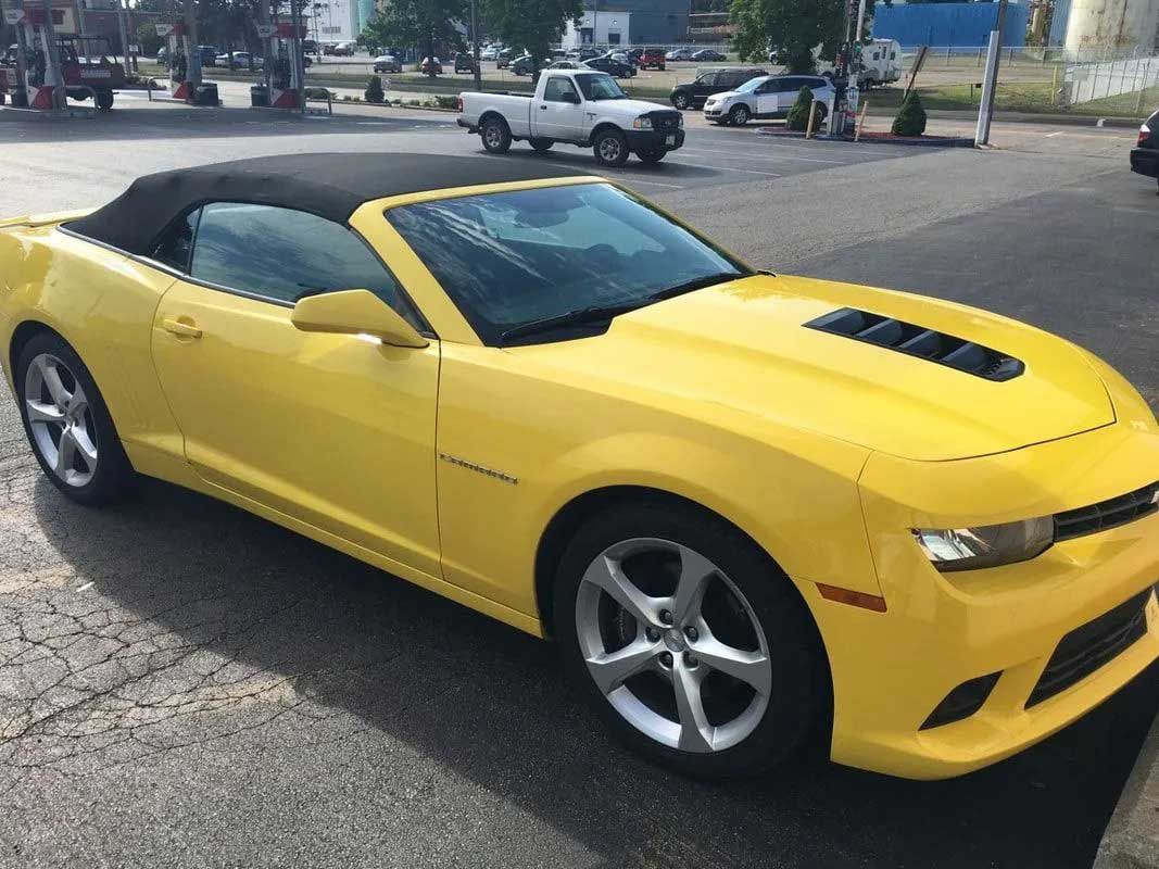 Yellow convertible Camaro parked outdoors.