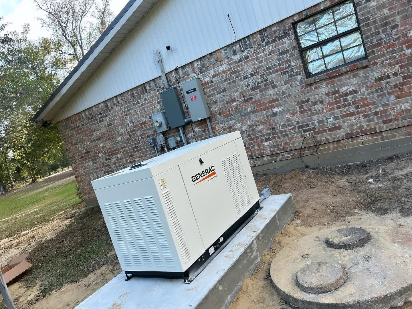A cream-colored Generac standby generator installed on a concrete pad next to a brick house exterior.