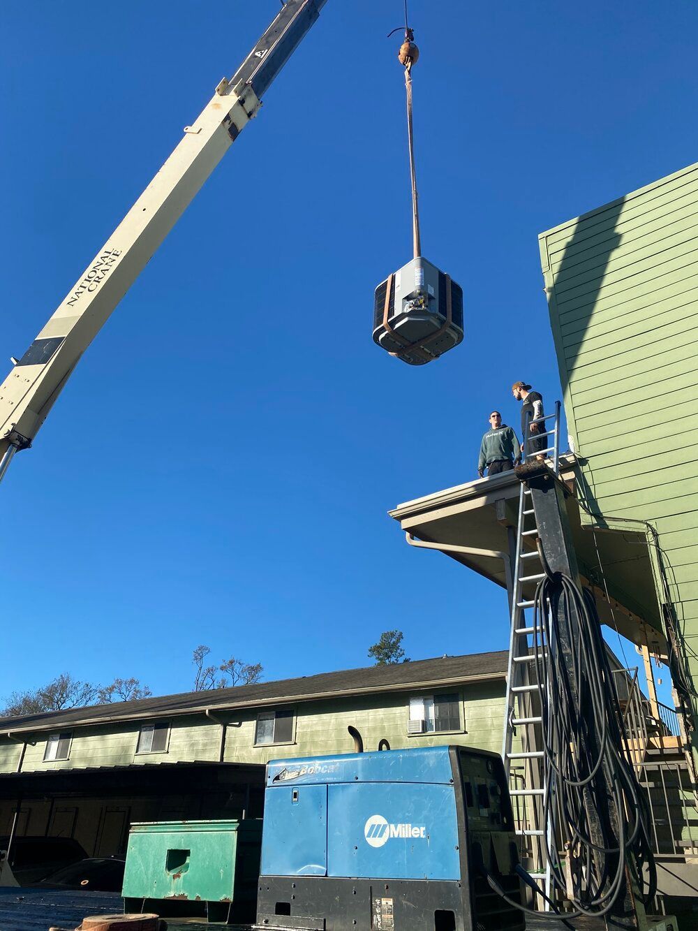 A crane is lifting a large object over a building