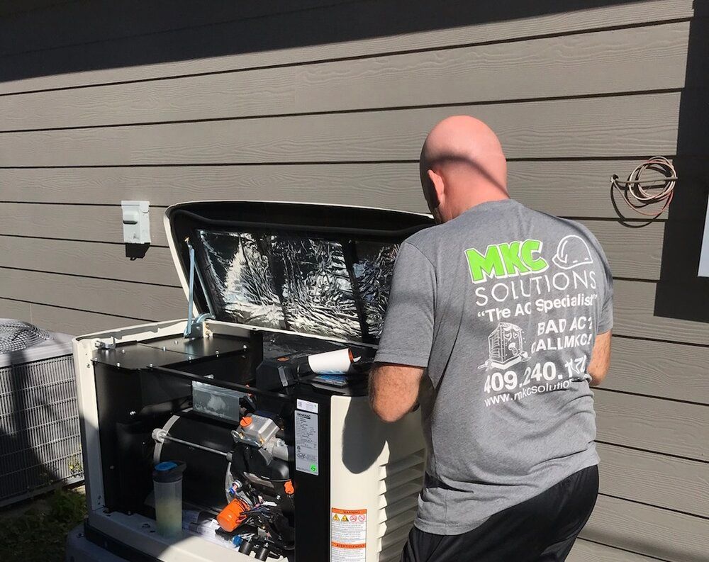A man is working on a generator outside of a house.