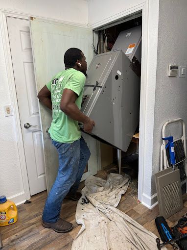 A man is carrying a large appliance into a closet.