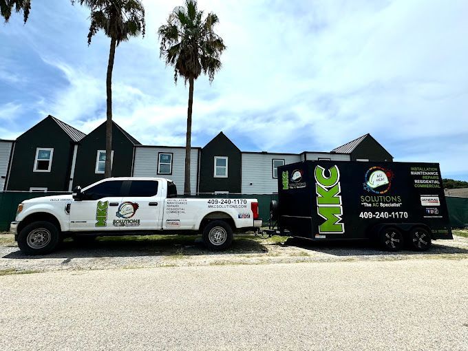 Two trucks are parked next to each other in front of a building.