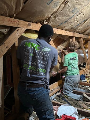 A man and a woman are working in an attic.