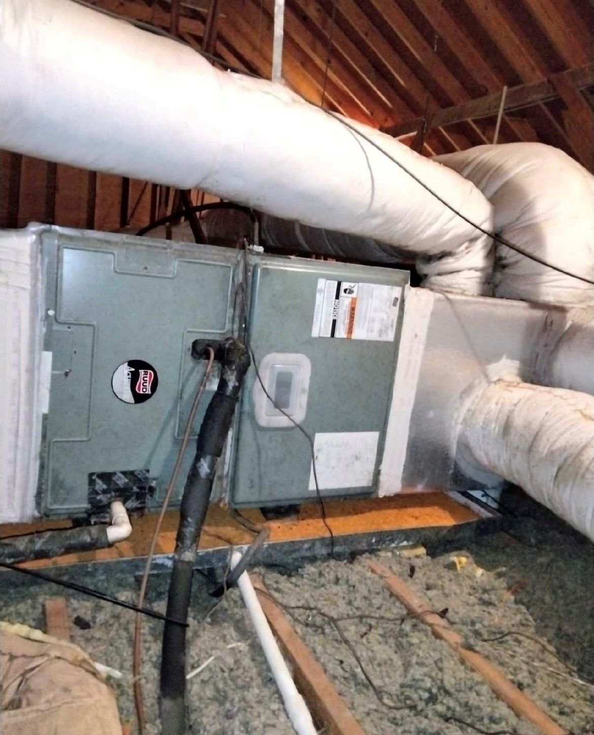 An air conditioner is sitting in the attic of a house