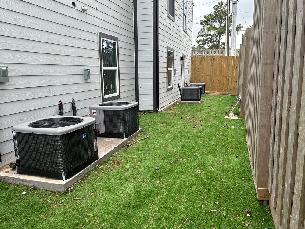 There are two air conditioners in the backyard of a house.