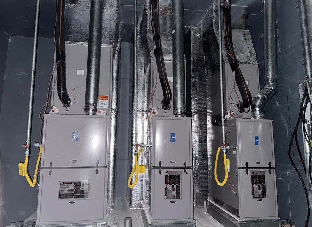 Three air conditioners are sitting next to each other in a room.