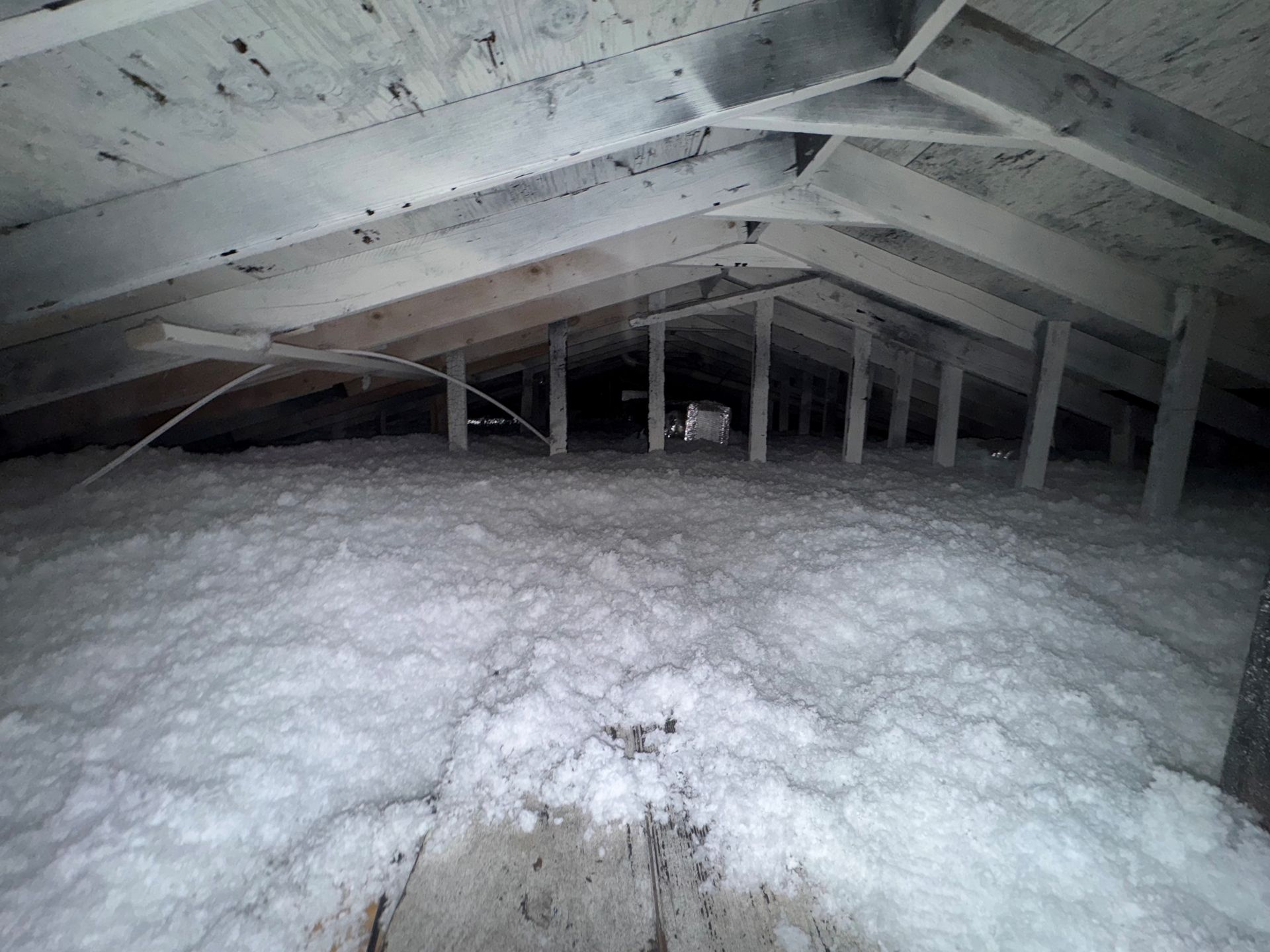 There is a lot of white foam in the attic of a house.