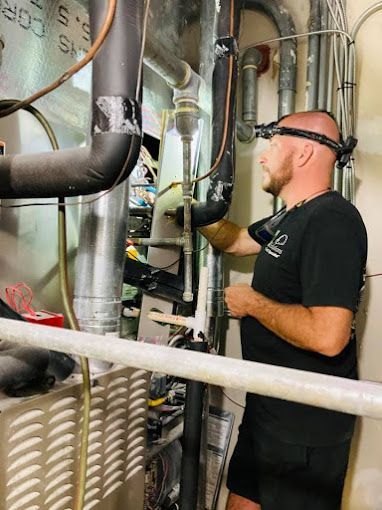 A man is working on a heating system in a building.