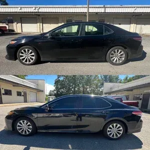 Black sedan parked outside a beige building, shown in side views under bright daylight.
