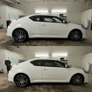 White sports coupe shown in two side-view angles inside a garage, with a black roof and rear spoiler