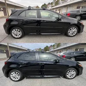 Black hatchback car parked on a residential street, shown in side view.