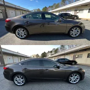 Dark gray sedan parked outdoors, shown from the side in a residential lot.