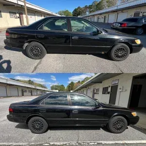 Black sedan shown in side view, parked in a driveway from two slightly different angles.