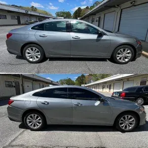 Two side views of a silver sedan parked in a lot by garages, windows tinted, in bright daylight