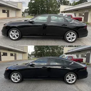 Black sedan parked in front of a building, shown in side view.