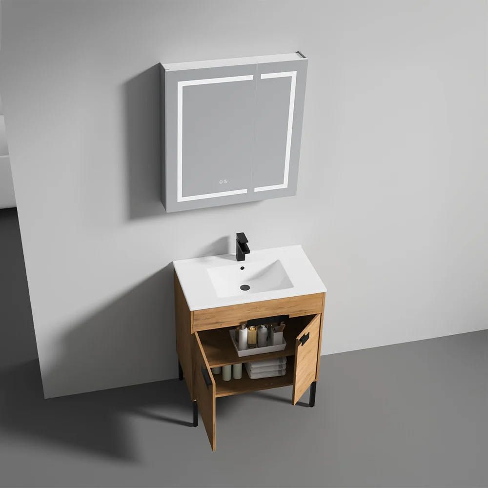 Bathroom vanity with a wood cabinet, white countertop, black faucet, and lit mirror.