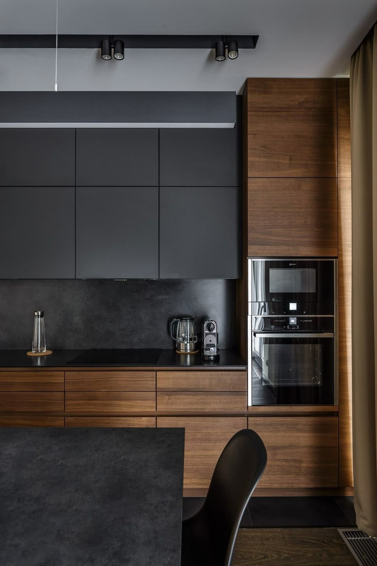 Modern kitchen with dark cabinetry, built-in appliances, and wood accents.