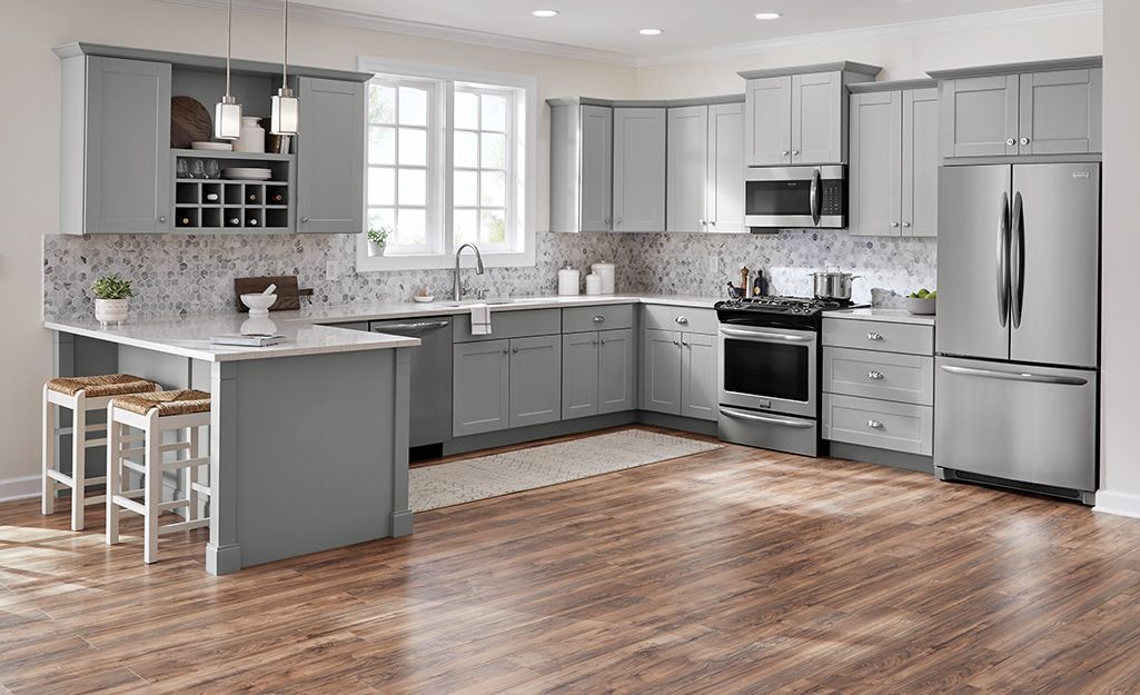 Gray kitchen with cabinets, stainless steel appliances, and wood flooring.
