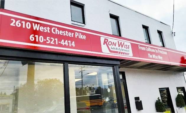 Exterior view of Ron Wise auto shop at 2610 West Chester Pike. Red sign with address and phone number above storefront.
