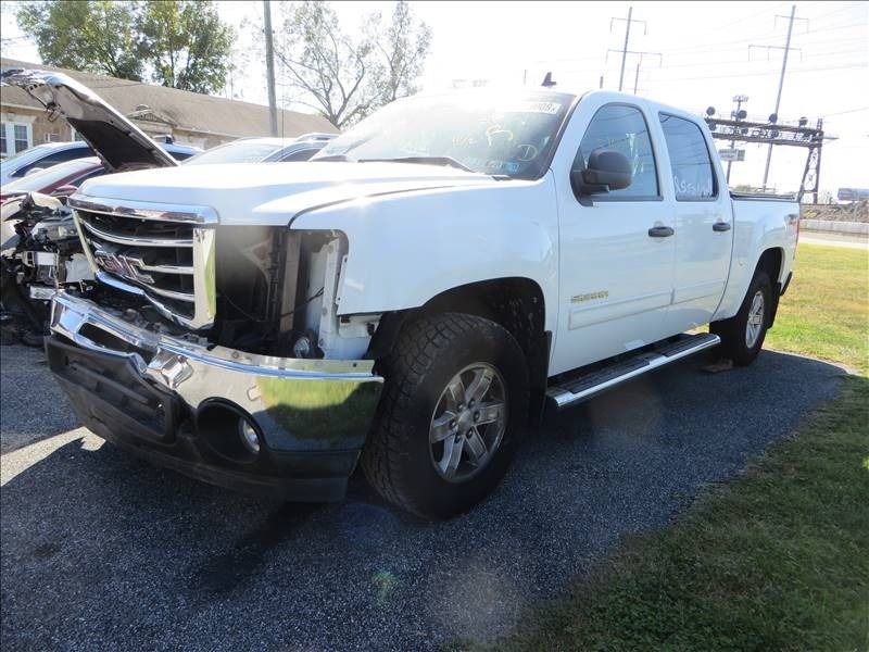 White pickup truck with front-end damage; parked outdoors.