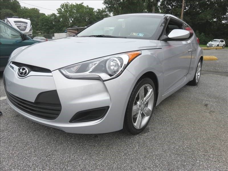 Silver Hyundai Veloster parked in a parking lot.