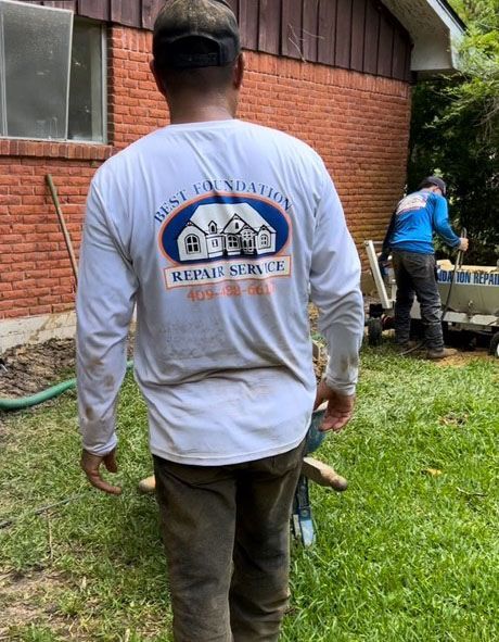 Two construction workers by a brick building