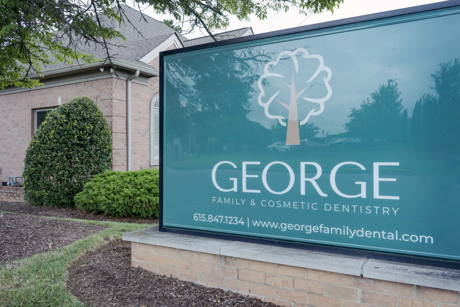 A sign for George Family & Cosmetic Dentistry is in front of a building.