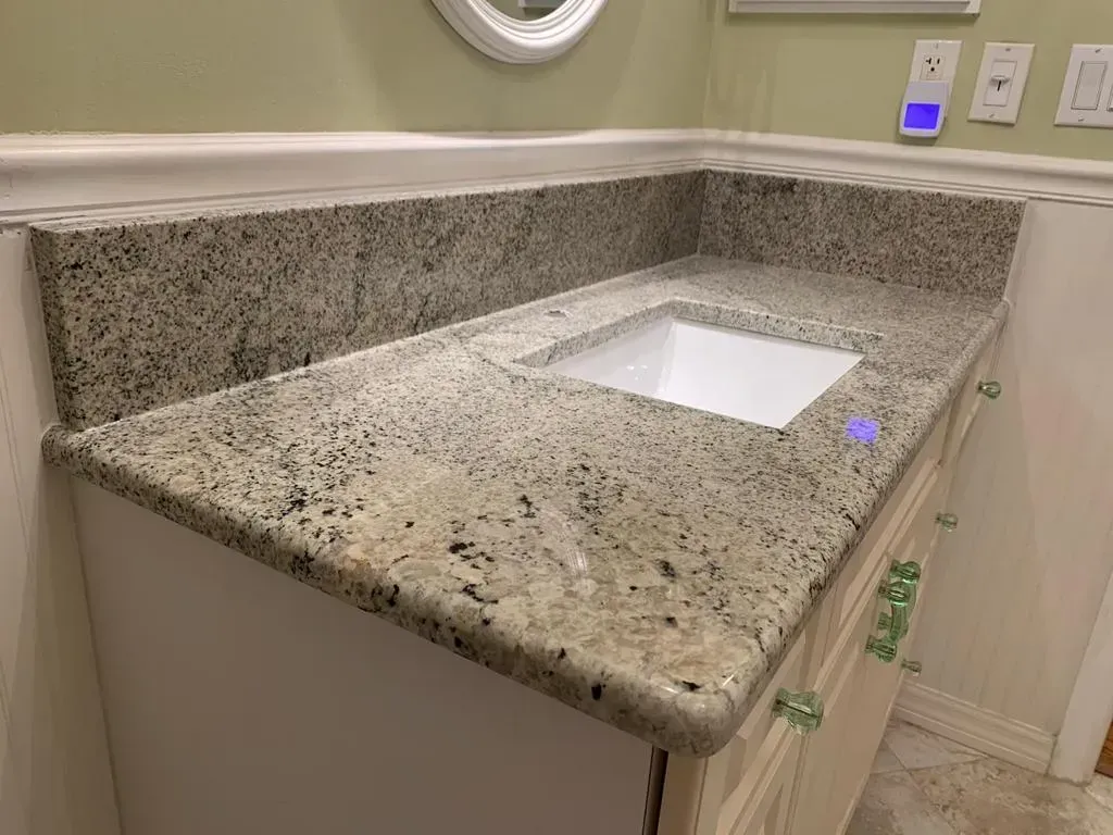 Granite bathroom vanity with under-mount sink and light beige cabinetry