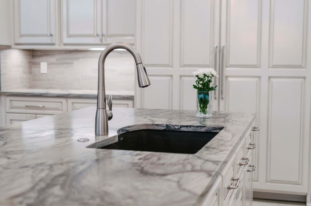 Luxury kitchen with dark wood cabinets, granite island, stainless appliances, and pendant lights