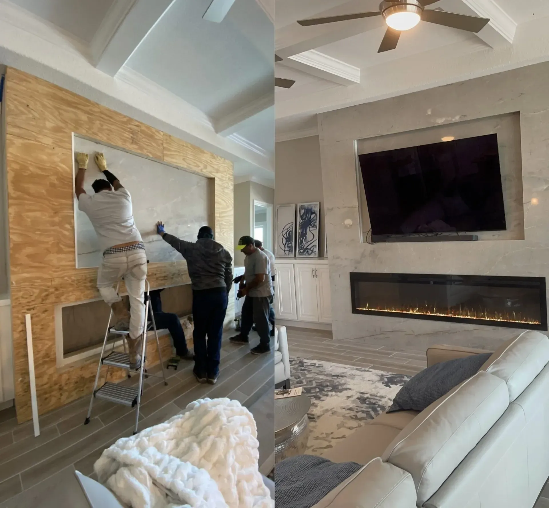 Workers installing a large framed panel above a fireplace in a bright living room