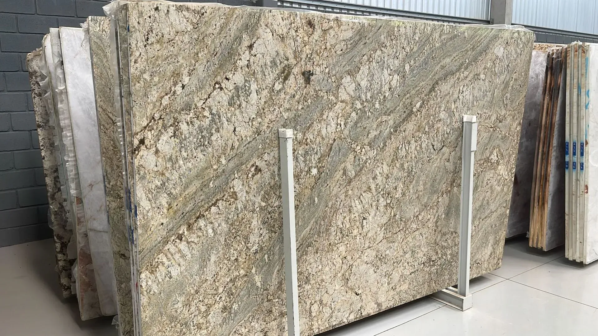 Large slabs of beige and gray stone displayed upright in a showroom or warehouse