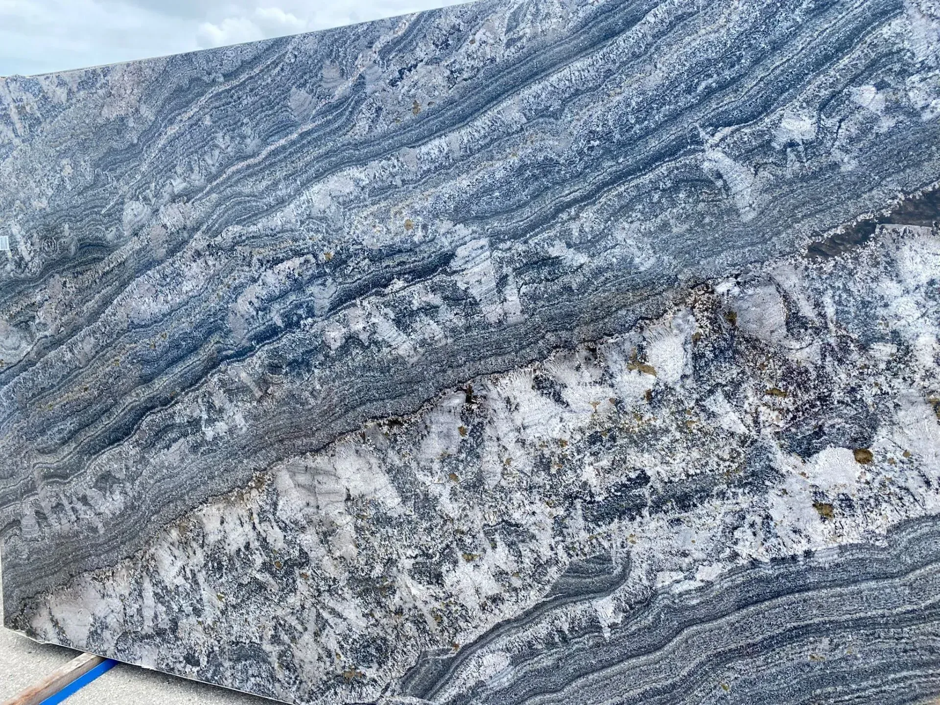 Close-up of blue-gray patterned stone with white veining and rough, textured surface
