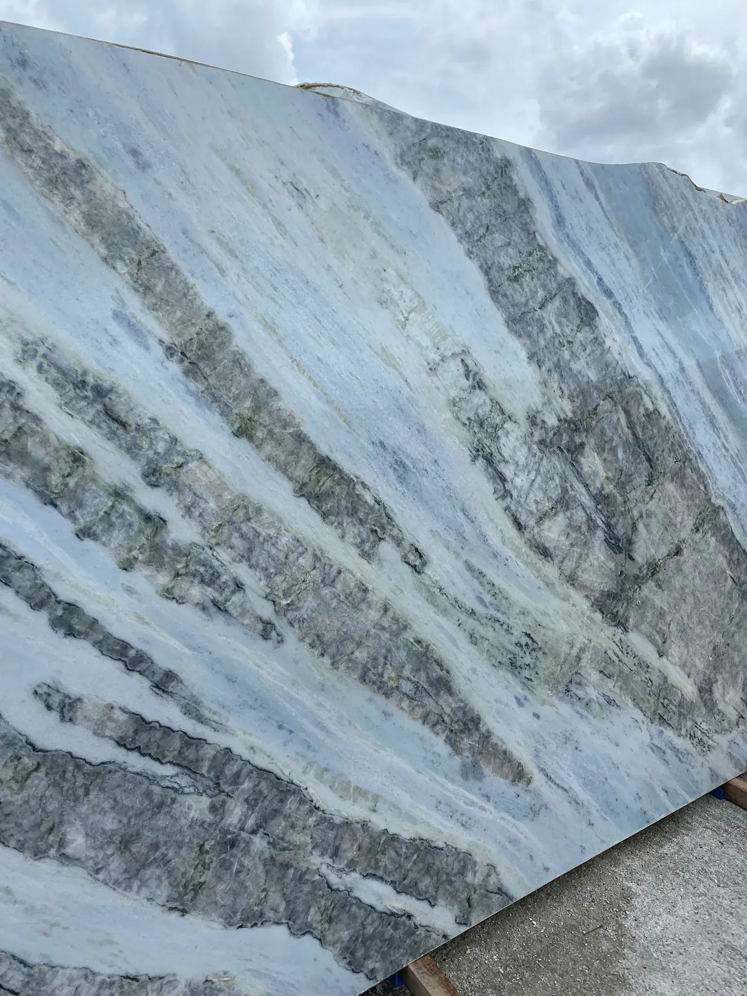 Close-up of a blue-gray textured stone surface with diagonal veining and streaks