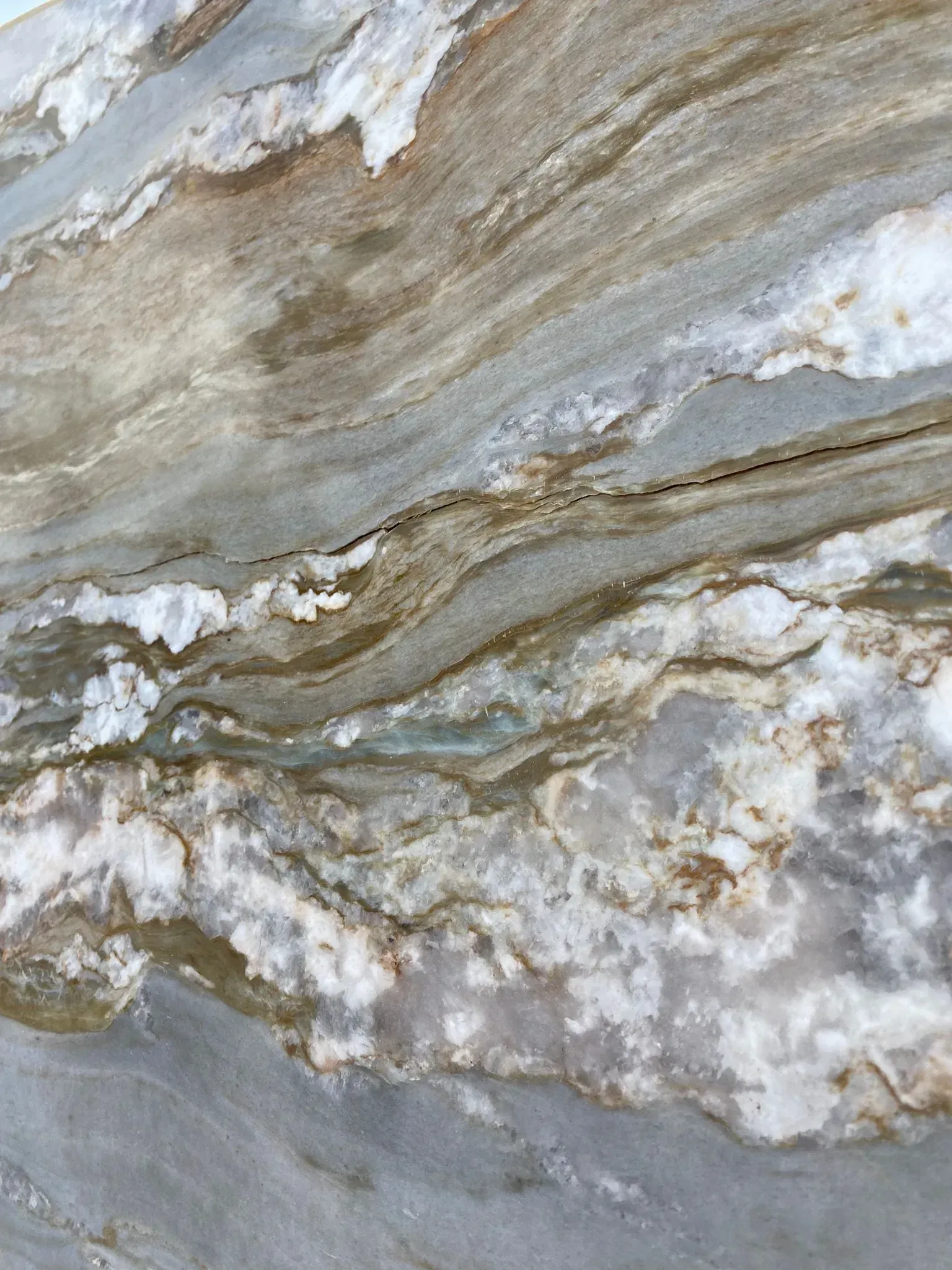 Swirling gray, white, and gold marble texture with layered, veined patterns