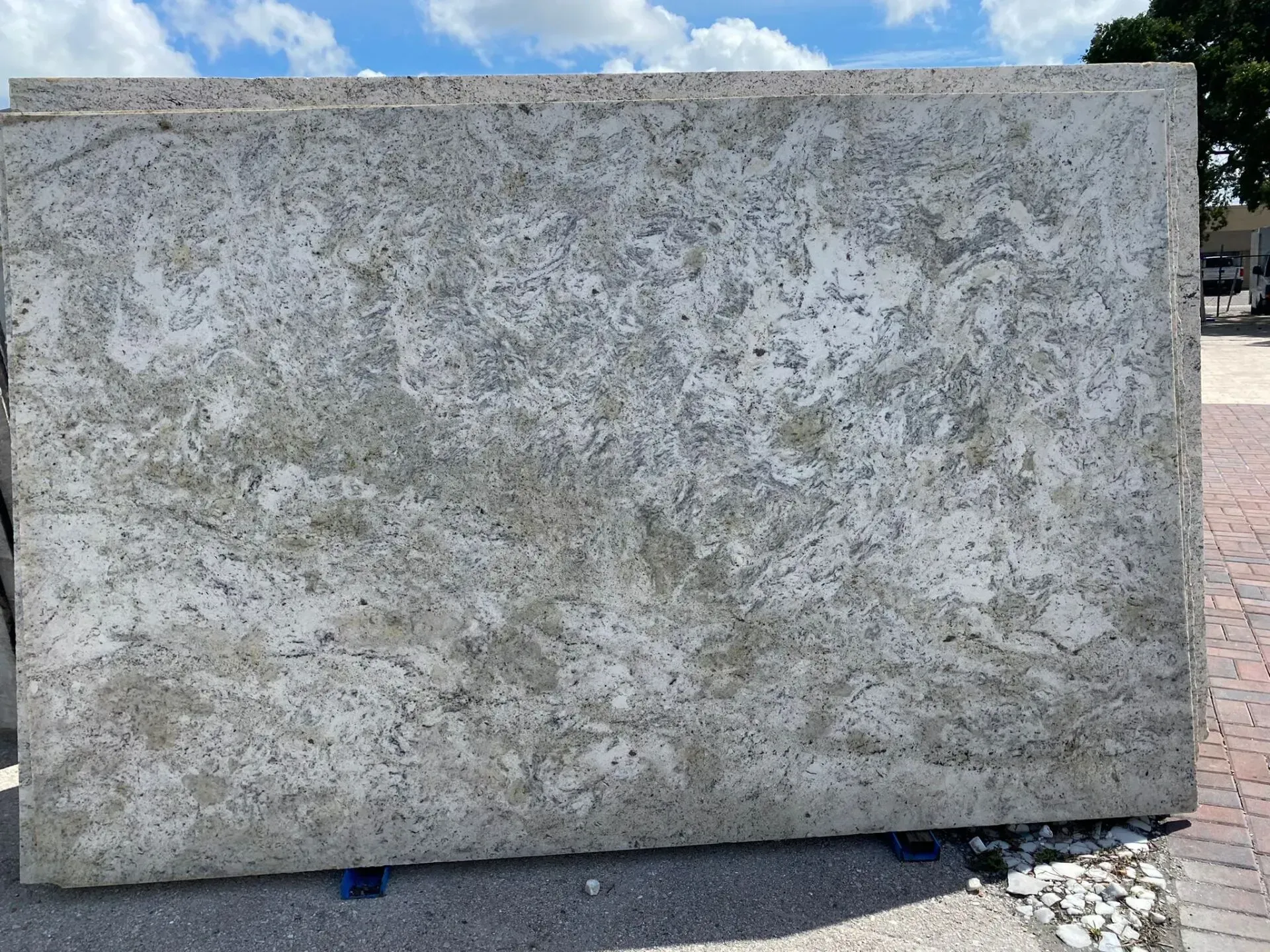 Large rectangular gray stone slab outdoors against a blue sky