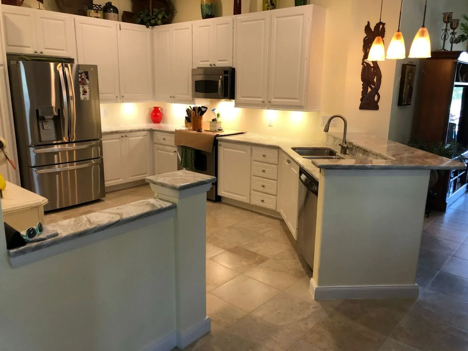 Bright modern kitchen with white cabinets, stainless appliances, and granite counters