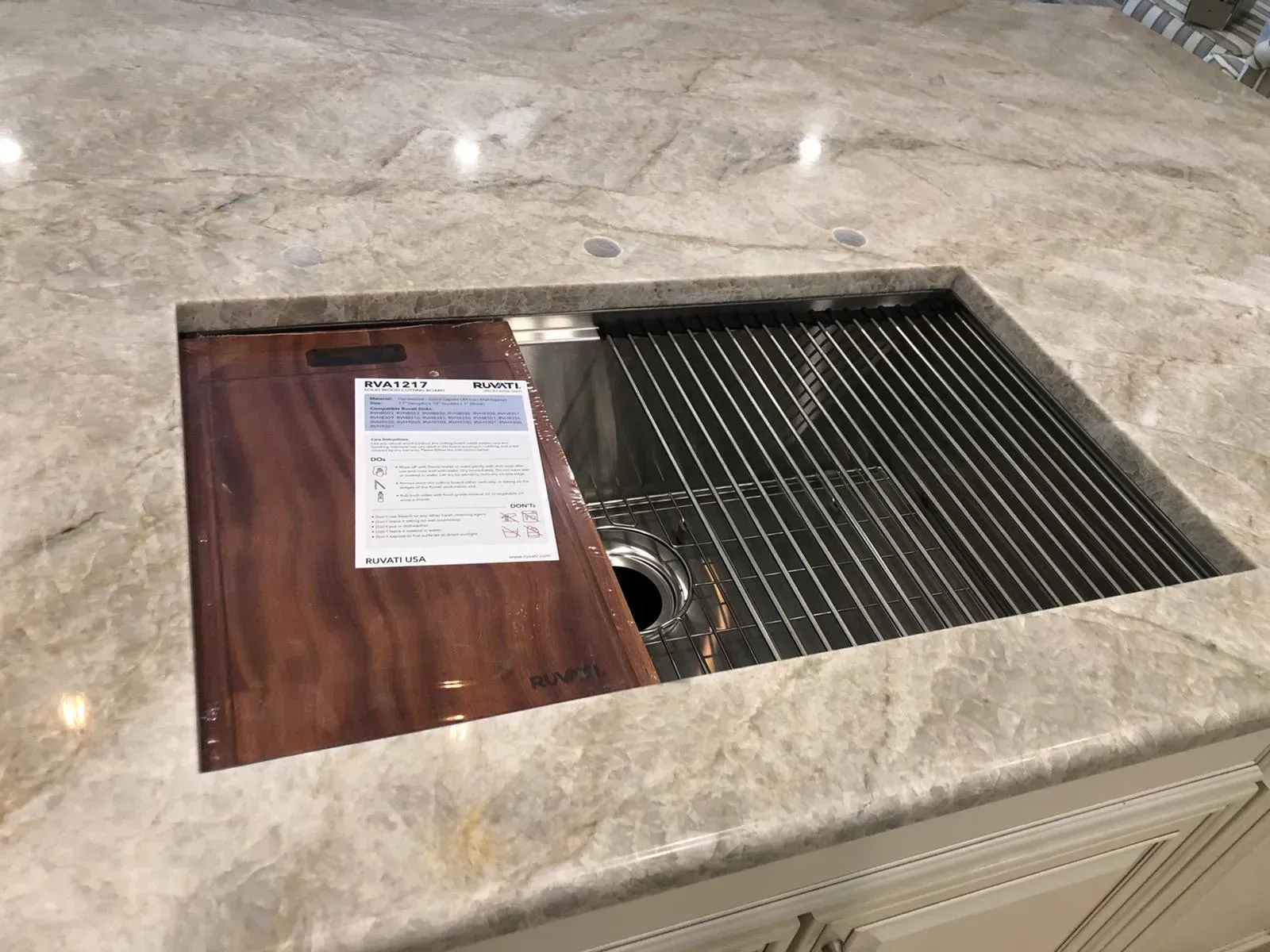 Marble counter with a recessed metal sink or grill, a paper notice taped on top.