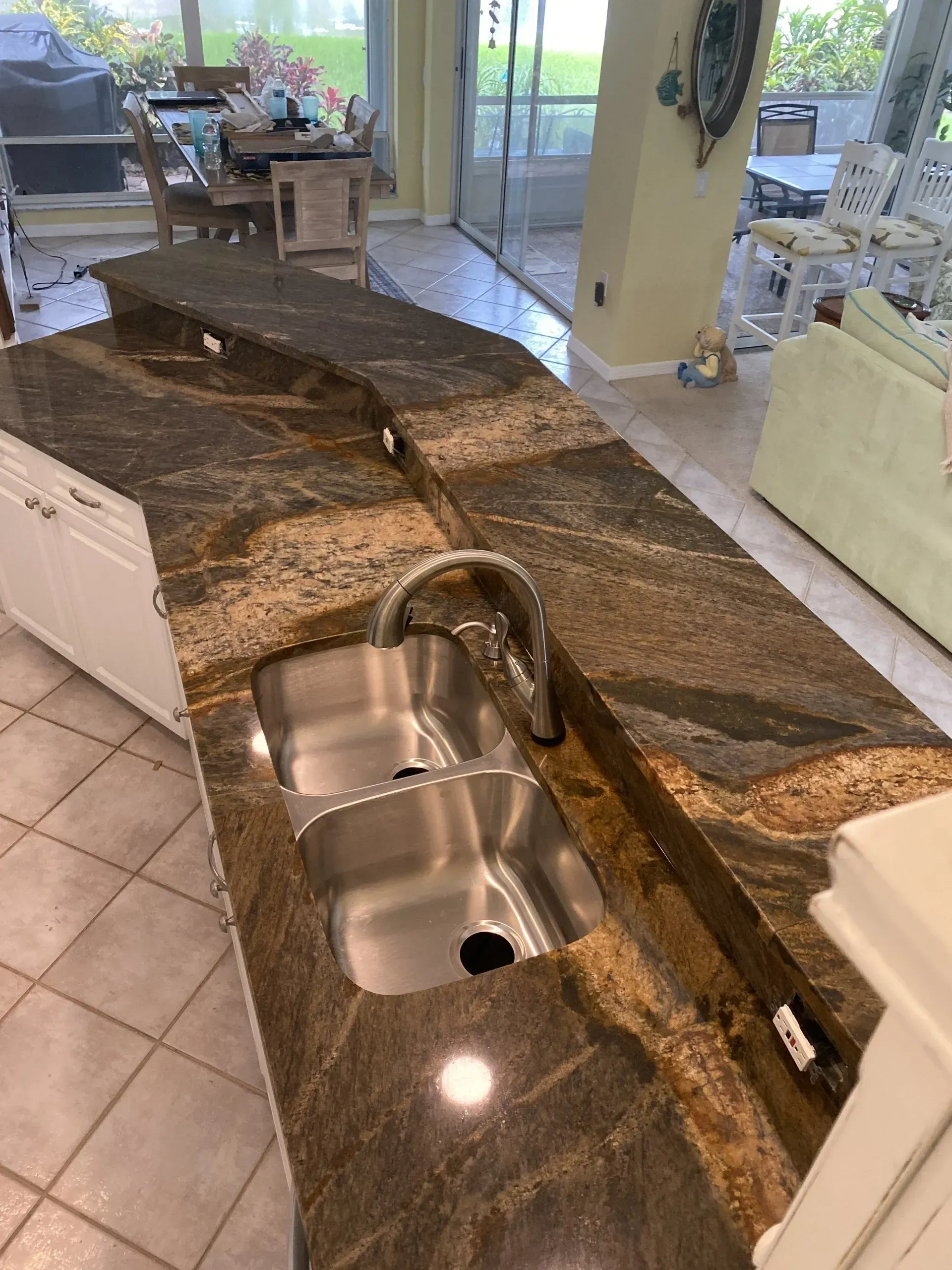 Kitchen island with granite countertop and double sink in an open living area